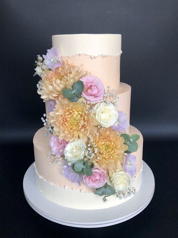 Pink and white wedding cake with fresh flowers
