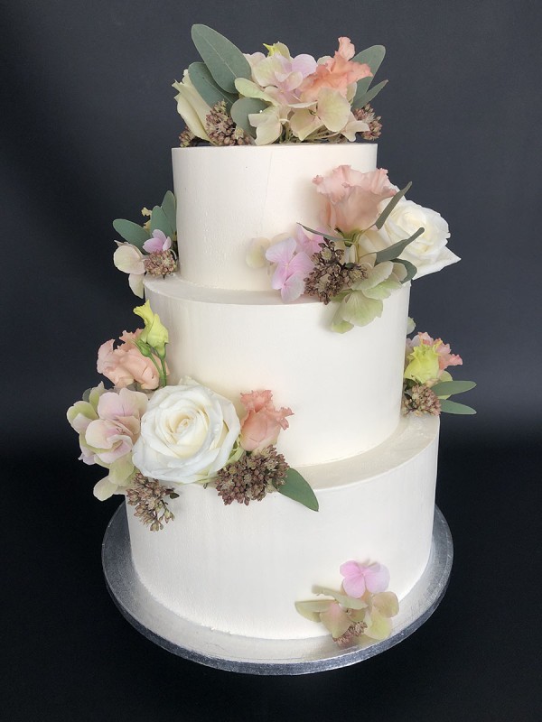 White wedding cake with fresh flowers