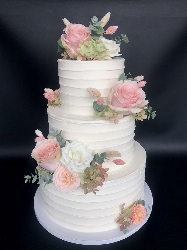 White wedding cake with fresh flowers