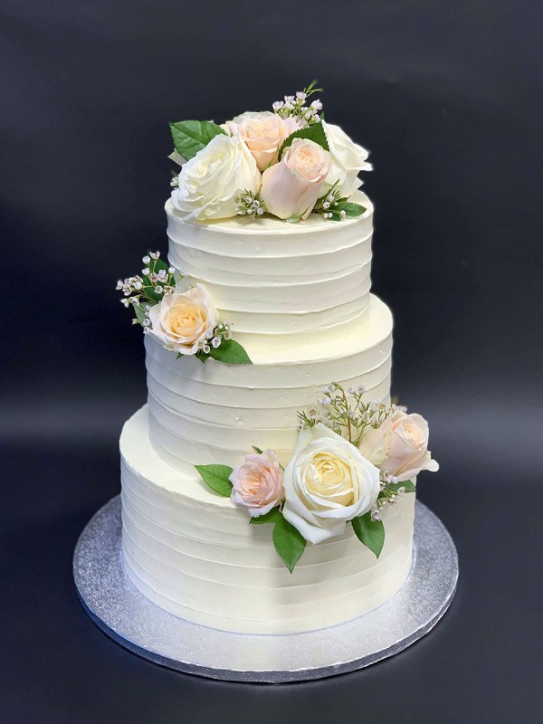 White wedding cake with fresh flowers