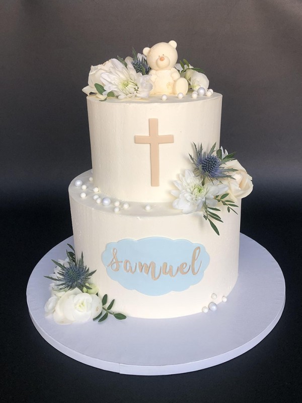 Christening cake with fresh flowers and chocolate teddy bear