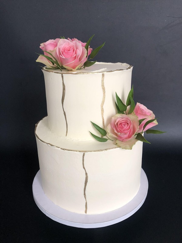 Wedding cake with fresh flowers and golden spots