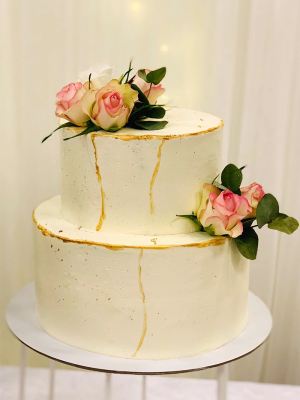 Wedding cake with fresh flowers and golden spots